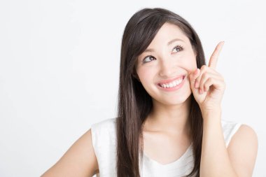 Genç ve güzel bir Japon kadın beyaz arka planı işaret ediyor. 