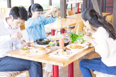 Asyalı arkadaşlar restoranda yemek yiyorlar. 