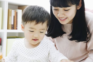 Evde annesiyle oynayan tatlı Japon çocuk.