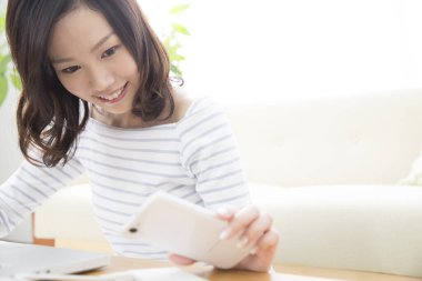 Masada akıllı telefon kullanan genç bir kadın. 