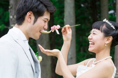 Asyalı düğün çifti, gelin damadı pastayla besliyor