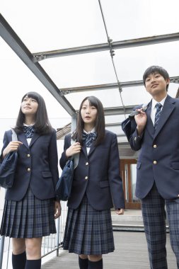 Okulda çantalı genç Japon öğrencilerin portresi.