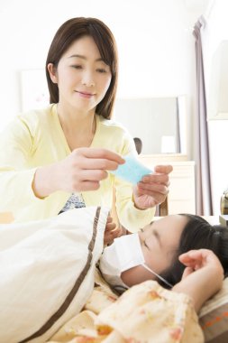 Asyalı kadın çocuğuna bakıyor. 