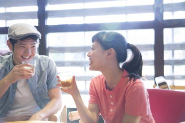 Genç mutlu çift kafede bira içiyor.