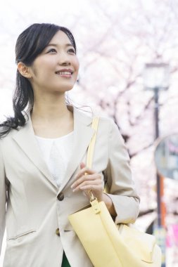 Sırt çantalı bir kadın parkta yürüyor. 