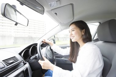 Mutlu Asyalı kadın araba kullanıyor.