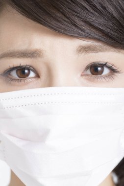 Yüz maskesi takan Asyalı kadın, yakın plan.