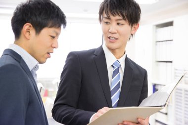 İki Asyalı iş adamı proje üzerinde birlikte çalışıyor.