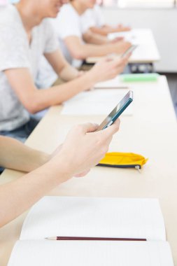 öğrenciler cep telefonlarını kullanarak kapatırlar 