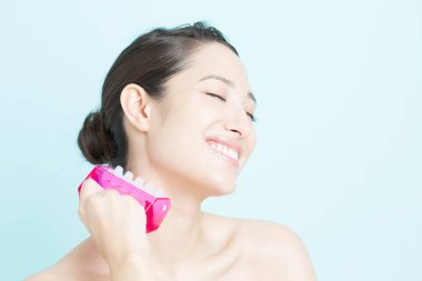 Asyalı kadın kendine masaj yapıyor. 