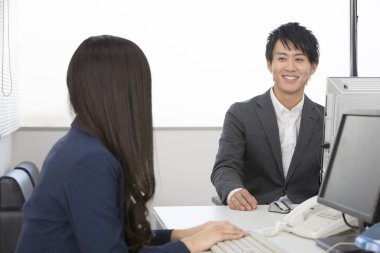 Sınıfta bilgisayar üzerinde çalışan Asyalı genç bir öğrencinin portresi. 