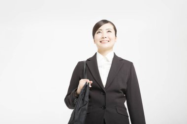 Beyaz arka planda el çantası olan güzel bir Japon iş kadınının stüdyo fotoğrafı. 