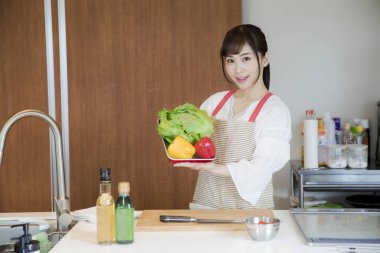 Mutfakta sebzeli genç Asyalı kadın. 