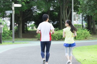 Sportif genç Asyalı çift parkta koşuyor.