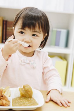 Güzel Asyalı kız evde Japon yemeği yiyor.