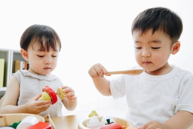 Evde oyuncaklarla oynayan sevimli Japon çocukları.