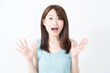 Genç Asyalı kadın beyaz arka planda şaşırdı. 