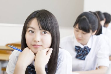 Asyalı öğrenciler sınıfta okuyor.