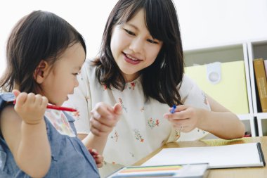 Annesiyle resim çizen tatlı Asyalı kız.