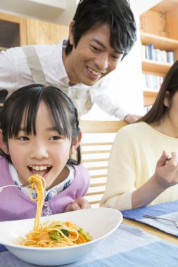 Genç bir aile erişte yiyor.