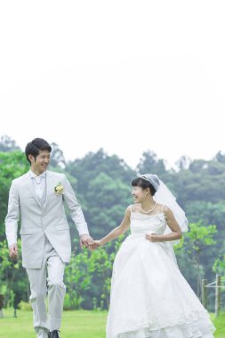 Parkta poz veren Asyalı gelin ve damat 