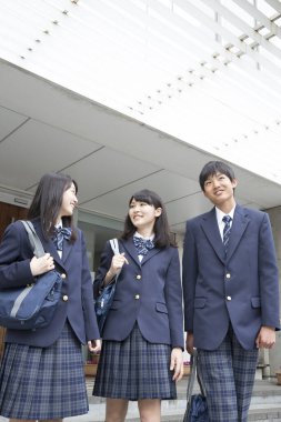 Çantalı gülümseyen Japon öğrencilerin portresi. 