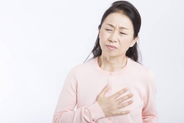 Yaşlı Asyalı kadının göğüs ağrısı var, kalp krizi geçirmiş, beyaz tenli. 