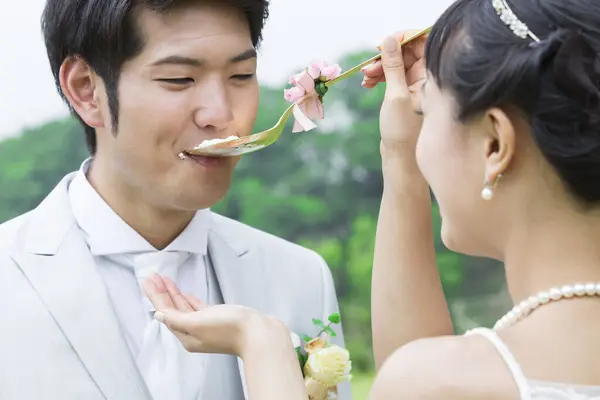 Asian wedding couple, bride feeding groom with cake
