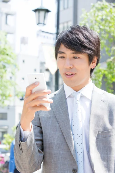 Yakışıklı Asyalı Adamı Sokakta Cep Telefonu Kullanıyor — Stok fotoğraf