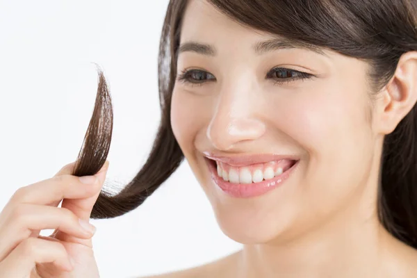 日本の女性は彼女の長い髪を保持し 髪の端を分割することを見ています — ストック写真