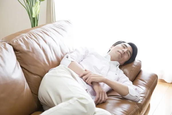 young man sleeping on couch