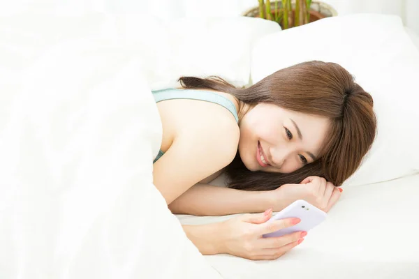 Красива Молода Дівчина Лежить Своєму Ліжку Смартфоном — стокове фото