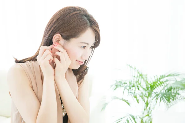 美丽的亚洲女人调整耳环 — 图库照片