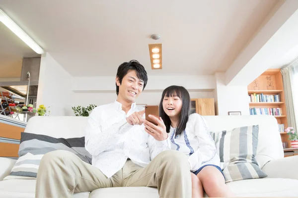 Gülümseyen Baba Kızı Evde Akıllı Telefon Kullanıyor — Stok fotoğraf