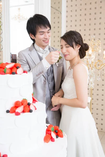 漂亮的新郎用结婚蛋糕喂漂亮的新娘 — 图库照片