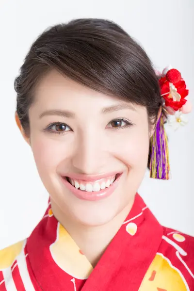 孤立した日本の伝統的な着物の笑顔を身に着けた美しい若い女性の肖像 — ストック写真