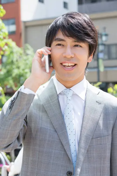 Yakışıklı Profesyonel Japon Adamı Gülümseyerek Telefonla Sokakta Konuşuyor — Stok fotoğraf