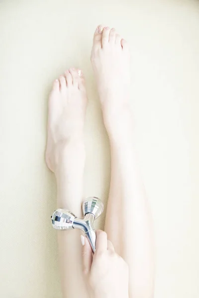 Młoda Kobieta Siedzi Kanapie Masuje Nogę Wałkiem Masażu — Zdjęcie stockowe