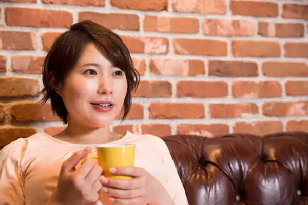 年轻的亚洲女孩在咖啡店喝咖啡 — 图库照片