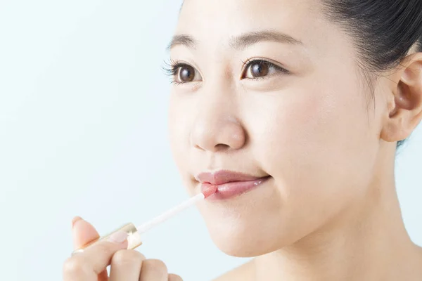 唇の光沢を適用する若い美しいアジアの女性 — ストック写真