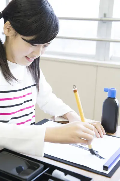 教室で勉強するかわいいアジアの女子高生 — ストック写真