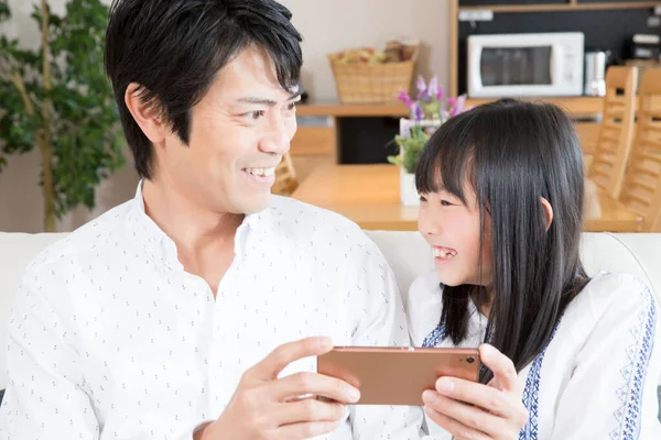 Gülümseyen Baba Kızı Evde Akıllı Telefon Kullanıyor — Stok fotoğraf