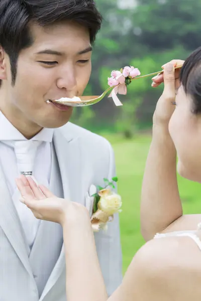 亚洲新婚夫妇 新娘用蛋糕喂新郎 — 图库照片