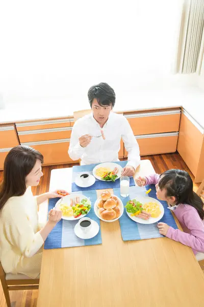 キッチンで一緒に朝食を持っている幸せなアジアの家族 — ストック写真