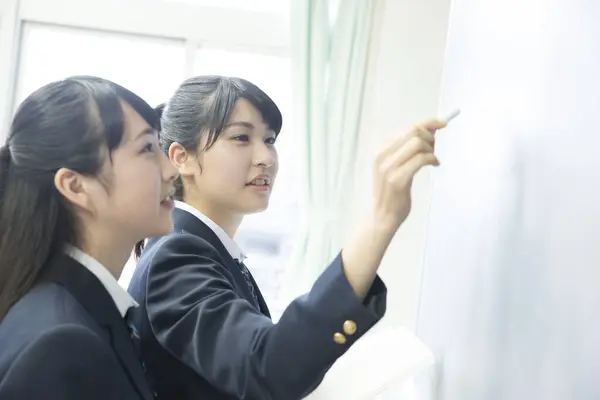 İki Asyalı kız öğrenci ders çalışıyor.