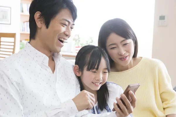 Mutlu Asyalı Aile Evde Akıllı Telefon Kullanıyor — Stok fotoğraf