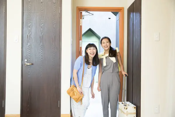 portrait of happy young women with luggage moving in cabin. travel concept