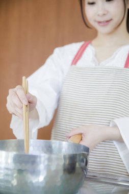 Güzel Japon kadın mutfakta yemek pişiriyor.