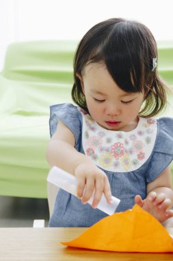 Küçük kız kağıtlarla oynuyor.