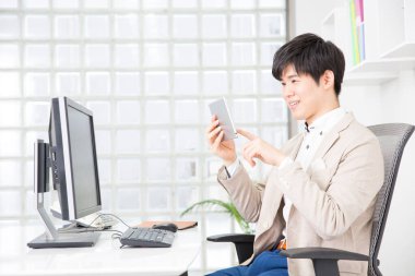 Ofisteki tablet bilgisayarda çalışan adam.